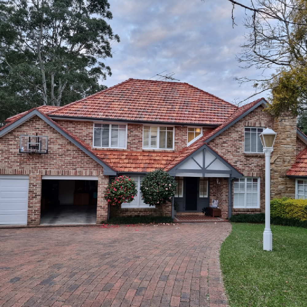 a brick house with a driveway and a lawn